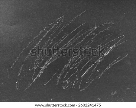abstract texture of chalk scribbled on a chalkboard. Chalkboard with white chalk stains for background or copy space for text and designs. White chalk dust on a chalkboard.