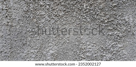 The abstract texture of the gray uneven cement wall.