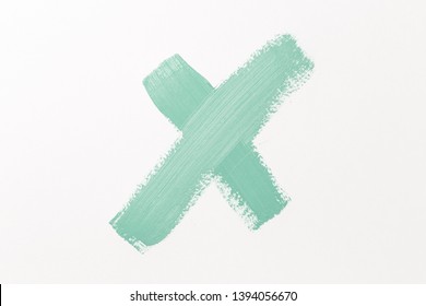 Abstract texture of mint paint on paper. Brush and paint texture. The symbol with the letter X