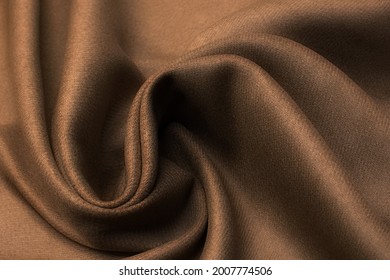 Abstract texture of natural beige or brown color fabric as concept background. Fabric texture of natural cotton or linen, silk or satin, wool or jersey textile material. Luxurious dark background.
