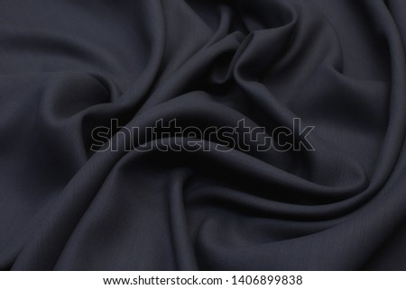 Abstract texture of natural black or dark gray color fabric as concept background. Fabric texture of natural cotton or linen, silk or satin, wool or jersey textile material. Luxurious dark background.