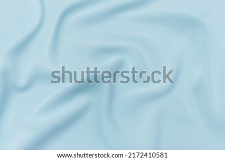 Abstract texture of natural light blue color fabric as concept of luxurious background. Fabric texture of natural cotton or linen, silk or satin, wool or jersey textile material.
