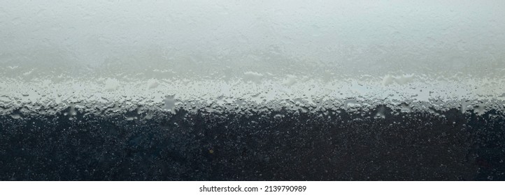 Abstract Texture Of Pastel Green, White And Black Frosted Glass Slab With Water Droplets And Water Markings. Background And Wallpaper Texture. Space For Text, Title.