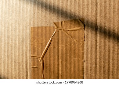 Abstract Texture Of A Wrinkled Cellotape On A Brown Cardboard Box Carton