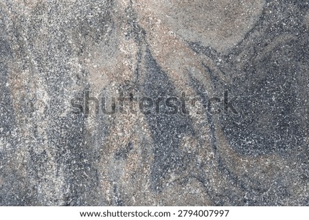 Abstract textured stone background featuring a blend of grey, tan, reddish-brown, with fine white flecks, natural grain patterns, speckles, and subtle surface cracks.