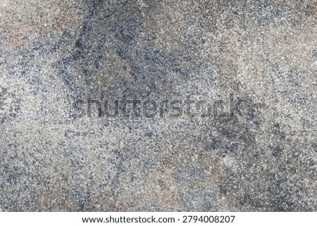 An abstract textured stone background featuring a blend of grey, tan, reddish-brown, with fine white flecks, natural grain patterns, speckles, and subtle surface cracks.