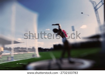 Abstract tilt shift of athlete throwing at stadium, blurred motion of track and field event under blue sky, dynamic sports background with lens blur.