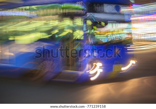 An abstract, time lapse photo of a magic blue bus\
in exciting downtown Seoul, South Korea, visible as blurry,\
energetic streaks of light.