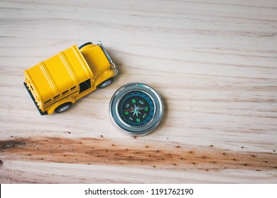 Abstract Top View Toy Car And Compass On Wooden Desk.