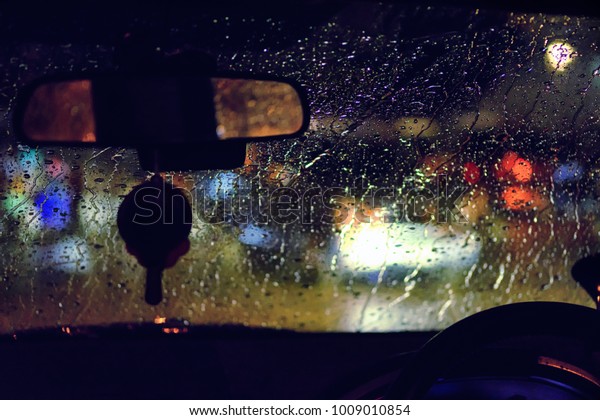 Abstract traffic in raining day. View from car\
seat. Background in retro filter. Road view through car window with\
rain drops at night