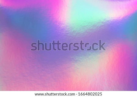 Abstract trendy rainbow holographic background in 80s style. Blurred texture in violet, pink and mint bright neon colors.