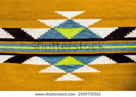 Abstract tribal pattern as background. Geometric chevron pattern color fabric. Selective focus close up. Traditional pattern backdrop. Horizontal lines and triangle shape forming a geometric pattern.