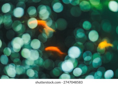 Abstract underwater composition featuring multiple blurry Goldfish swimming amidst shimmering green bokeh lights in India. This vibrant, soft-focus image creates a dreamlike ambiance.