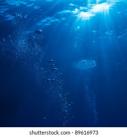 abstract underwater scene sunrays and air bubbles in deep blue sea