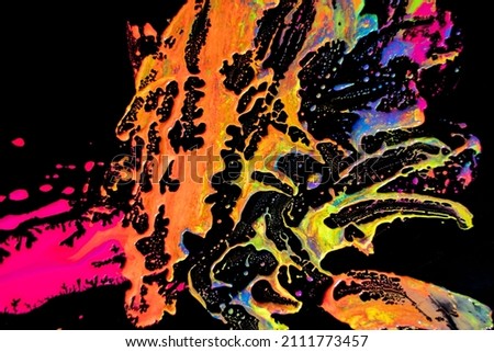 Abstract vibrant multi-color wet paint drops and splotch on black background. Bright orange and pink neon colors. Street art isolated