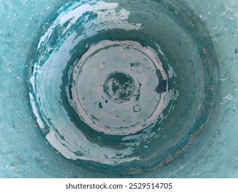 An abstract view of the interior of a weathered, turquoise-painted container. The peeling paint and uneven texture create a captivating visual pattern that evokes a sense of age and history. - Powered by Shutterstock