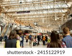 Abstract view of Waterloo Station with many passengers in a rush and a clock in London, England