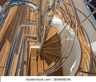 Abstract view of wooden curved spiral staircase on sundeck area of large luxury motor yacht