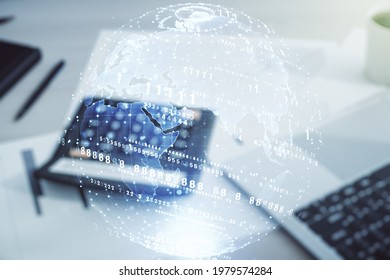Abstract virtual coding concept and world map hologram on calculator and laptop background. Multiexposure