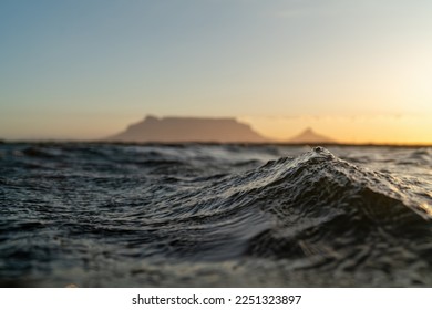 Abstract Water Surface Lake Wave windy day.Texture of dark water during sunset. Water surface in focus. Selective focus. Sunset Cape Town Table Mountain and Lions Head blurry background.  - Powered by Shutterstock