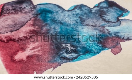 Abstract watercolor stain on paper. Close-up view of aquarelle wash color blue red. Painting detail. Wallpaper with watercolor blobs and splashes. Soft focus. film grain pixel texture. Defocused.