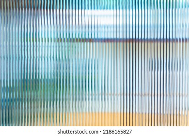 Abstract wave glass vertical line pattern background. Texture of wavy glass illuminated with multi-colored light. Blurry bright backdrop for banner, Soft focus image.