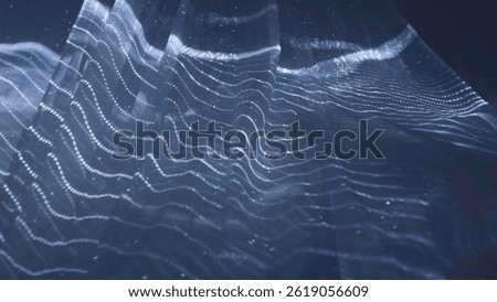 Abstract wavy surface gently moving with particles on dark background. Action