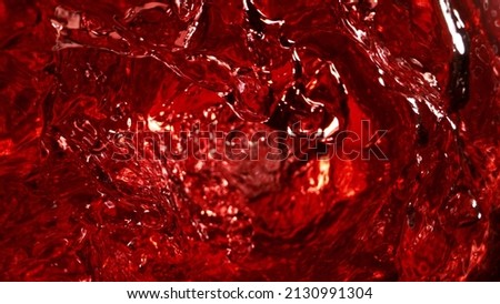 Abstract whirl shape of red wine, mixing liquid concept. Dark ruby colored background.