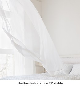 Abstract white room interior with waving curtain by fresh air