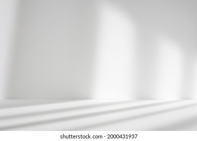 Abstract white studio background for product presentation. Empty room with shadows of window. Display product with blurred backdrop.