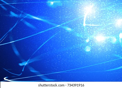 Abstract xmas blue magic sparkles or glitter lights. Christmas festive dark background. Defocused lines bokeh or particles. Template for design