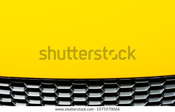 Abstract of\
yellow car hood with black hive\
pattern