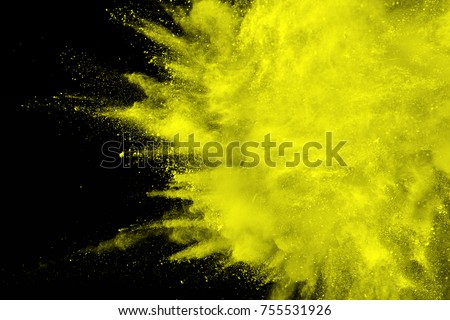 abstract yellow dust explosion on  black background.abstract yellow powder splattered on dark  background. Freeze motion of yellow powder splash.