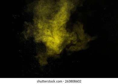 Abstract Yellow And Gold Powder Explosion On Black Background.