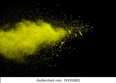 abstract yellow powder explosion on  black background.abstract yellow powder splatted on black background. Freeze motion of yellow powder exploding.