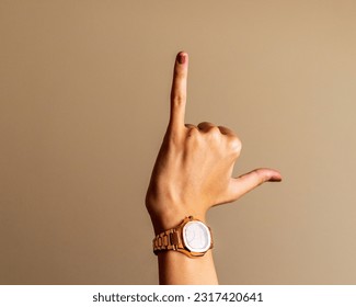 Abstract young woman's hand on brown background  - Shutterstock ID 2317420641