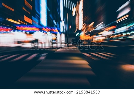 Abstract Zoom Blur of Scramble Crossing in Shinjuku City of Tokyo, Japan during the night with light from billboard and neon sign of business. Nightlife and modern urban lifestyle concept.