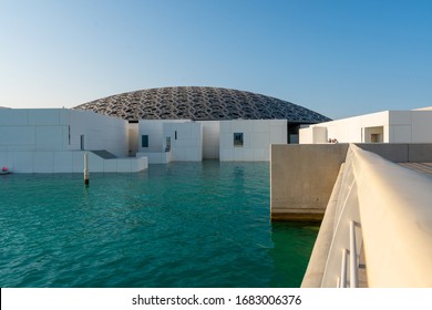 ABU DHABI / UAE – 02 01 2020: The day time view to Louvre Abu Dhabi building with white walls and beautiful grey roof structure. Place for Museums, galleries, exhibitions in United Arab Emirates.
