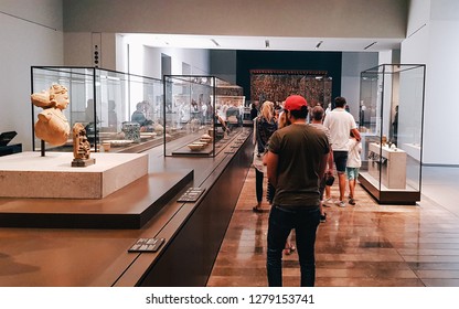 Abu Dhabi, UAE - 2018 - Tourists and Visitors viewing and admiring antiques at in the new art and civilization museum Louvre Museum in Abudhabi, United Arab Emirates