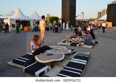 Abu Dhabi, UAE - Circa 2019. The European Tourists Eat Outdoor On The Emirates Floor Setting During The Food Festival