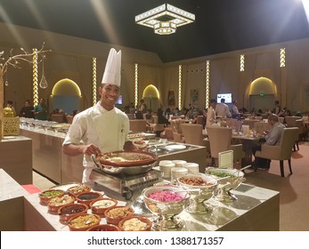 Abu Dhabi, UAE - May 2019. Young Cook Smiles Holding The Dish With Food In Front, At Ramadan Tent Of Emirates Palace