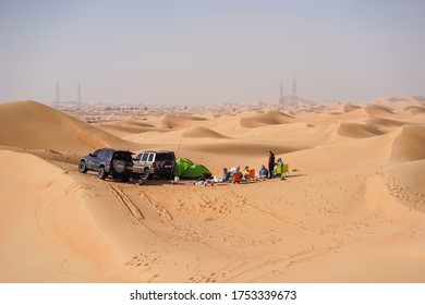 Abu Dhabi / United Arab Emirates - February 5, 2020: Large Group Of People Camping In Beautiful Desert Dunes With 4x4 Vehicles