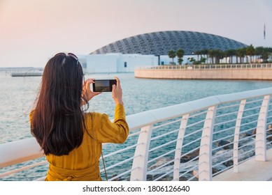 Abu Dhabi, United Arab Emirates - November 30, 2019: Female Traveler Taking Photos At Louvre Museum In Abu Dhabi Emirate Of The United Arab Emirates At Sunset