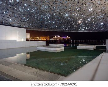 Abu Dhabi, United Arab Emirates - December 20, 2017: The Louvre Museum With Modern Design Exterior Luminated At Night 