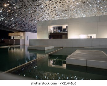 Abu Dhabi, United Arab Emirates - December 20, 2017: The Louvre Museum With Modern Design Exterior Luminated At Night 