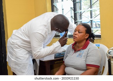 Abuja  Nigeria - August 09, 2021: African Medical Doctor Diagnosing for Eye Treatment in Rural clinic
