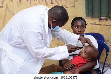 Abuja  Nigeria - March 06, 2021: African Medical Doctor giving treatment in Rural clinic