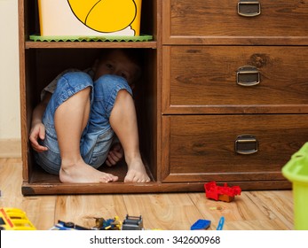 abuse and cruelty to children - little boy is hiding in a cupboard in the room - Powered by Shutterstock