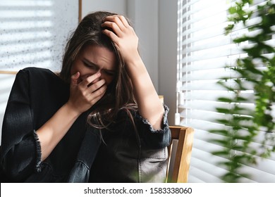 Abused young woman crying indoors. Domestic violence concept