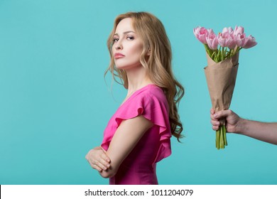 Abused Young Woman Is Turning Back To Male Hand Holding Flowers. Apology Concept. Isolated And Copy Space